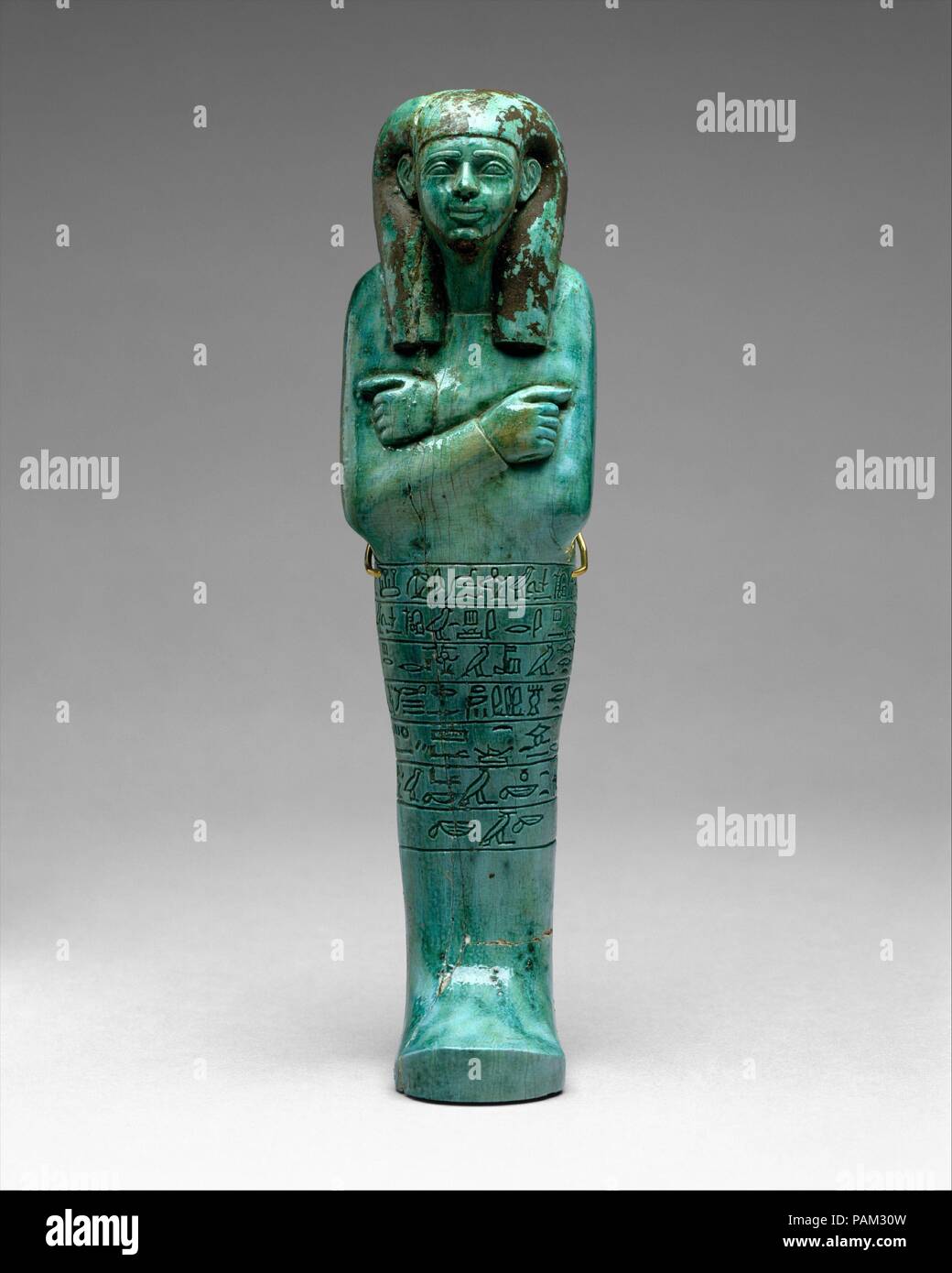 Shabti of Seniu. Dimensions: H. 27.3 cm (10 3/4 in); w. 8 cm (3 1/8 in); d. 5 cm (1 15/16 in). Dynasty: Dynasty 18, early. Reign: reign of Amenhotep I-Thutmose III. Date: ca. 1525-1504 B.C..  The shabti of the chief steward and scribe Seniu is a particularly fine example of this type of funerary figurine from the early New Kingdom. It is inscribed with the spell ensuring that the shabti will perform certain kinds of labor for the deceased in the afterlife. This work included maintenance of irrigation canals, and cultivation of the fields.   The shabti was discovered during excavations by the M Stock Photo