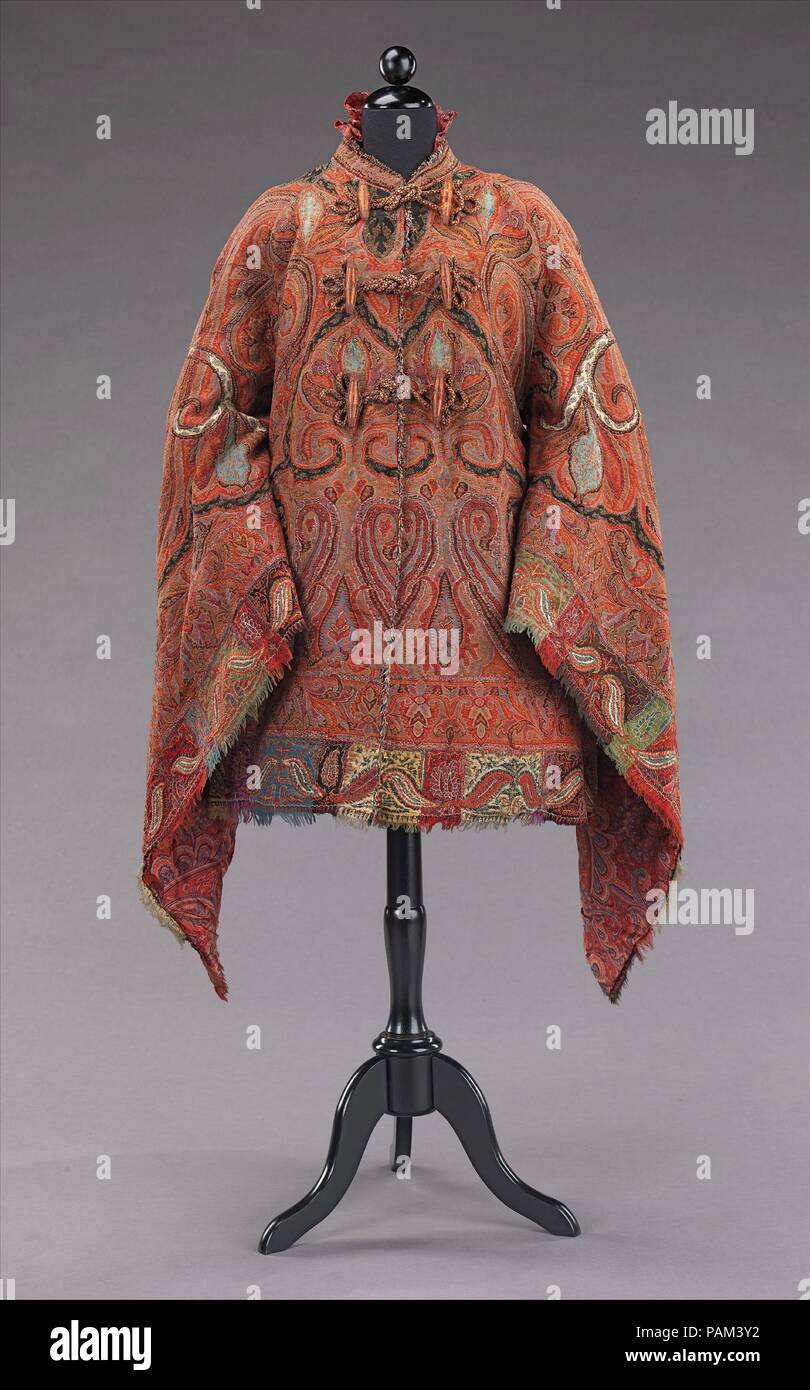 Dolman. Culture: American. Date: ca. 1875.  This dolman is made from a fine quality Indian shawl which is sewn to shape with beautifully symmetrical seaming and a well placed border.  The theme is carried into the interior with an elaborate paisley patterned silk lining making this truly a luxury item. In the 1870s shawls lost popularity due to its immense size and the reducing expanse of skirts to help support them.  Although some were retained as heirlooms, others were stitched into the more wieldy shape of the mantle. Museum: Metropolitan Museum of Art, New York, USA. Stock Photo