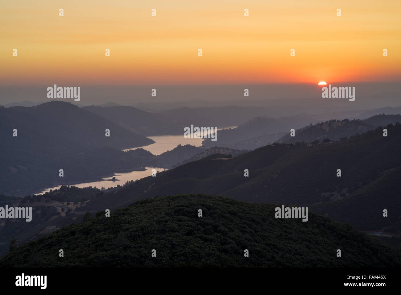 Don Pedro Lake and golden setting sun in the Sierra Foothills, on the  drive to Yosemite National Park Stock Photo