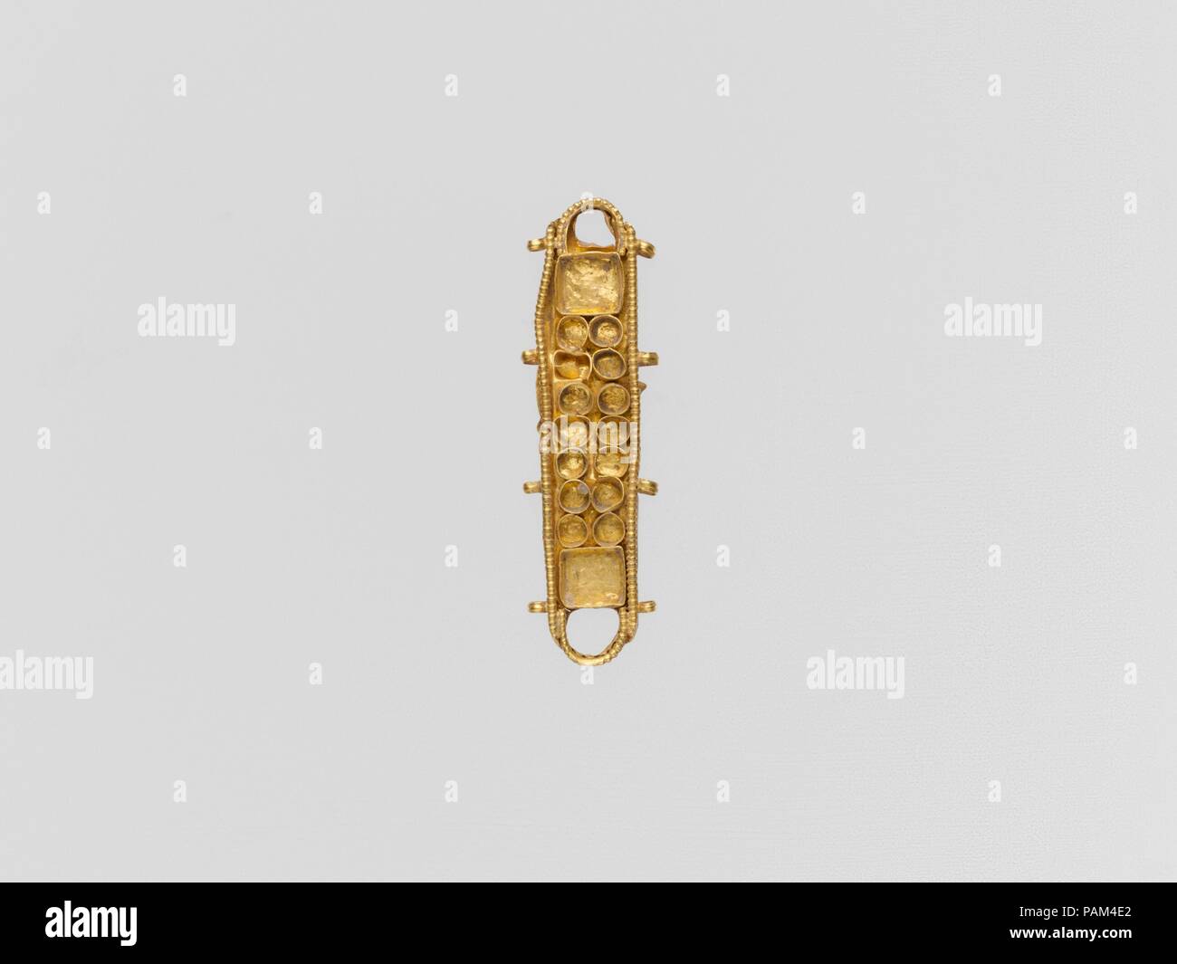 Gold ornament with cloisons. Culture: Roman. Dimensions: Other: 1 11/16 in. (4.3 cm). Date: 3rd-4th century A.D. or later.  Oblong bead ornament. Museum: Metropolitan Museum of Art, New York, USA. Stock Photo