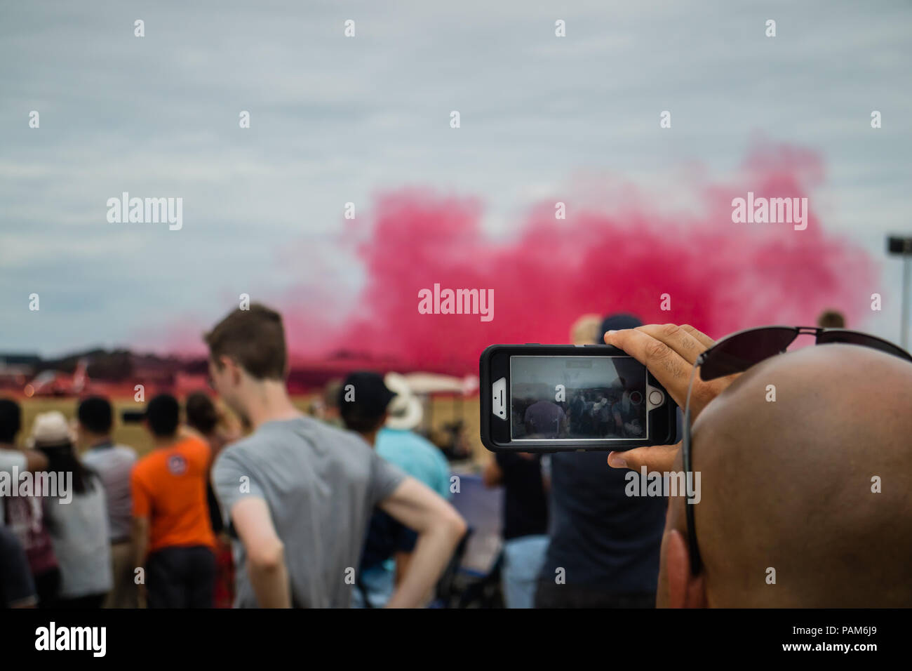 Crowd of people taking pictures of  The Royal Air Force (RAF) Red Arrows aerobatic team at the Farnborough International Airshow 2018. Stock Photo