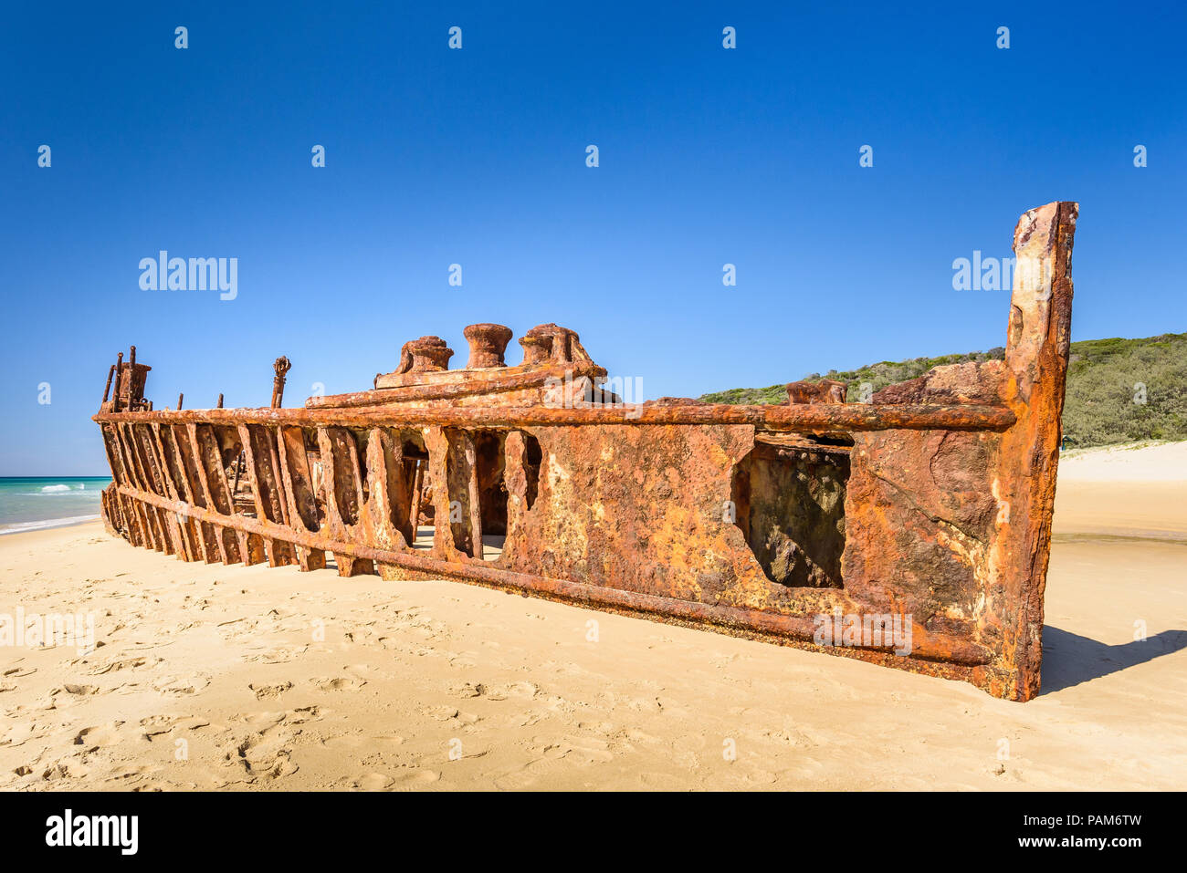 The rusting Maheno shipwreck, on the beach on Fraser Island, Queensland, Australia, photographed in bright sunlight against a clear blue sky Stock Photo