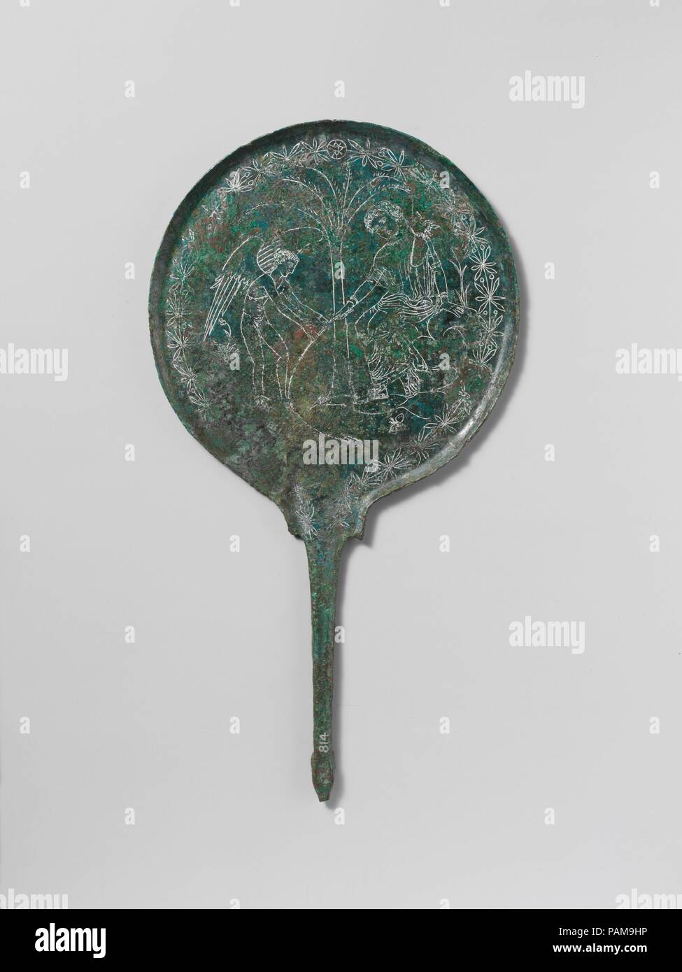 Bronze mirror. Culture: Etruscan. Dimensions: length  13 1/8 in. (33.3 cm); diameter  7 1/16 in. (18 cm). Date: ca. 350 B.C..  Aphrodite and Eros fishing  This scene of Eros assisting the fishing Aphrodite may be derived from similar representations on red-figure Greek pottery. Its significance is unknown. Museum: Metropolitan Museum of Art, New York, USA. Stock Photo