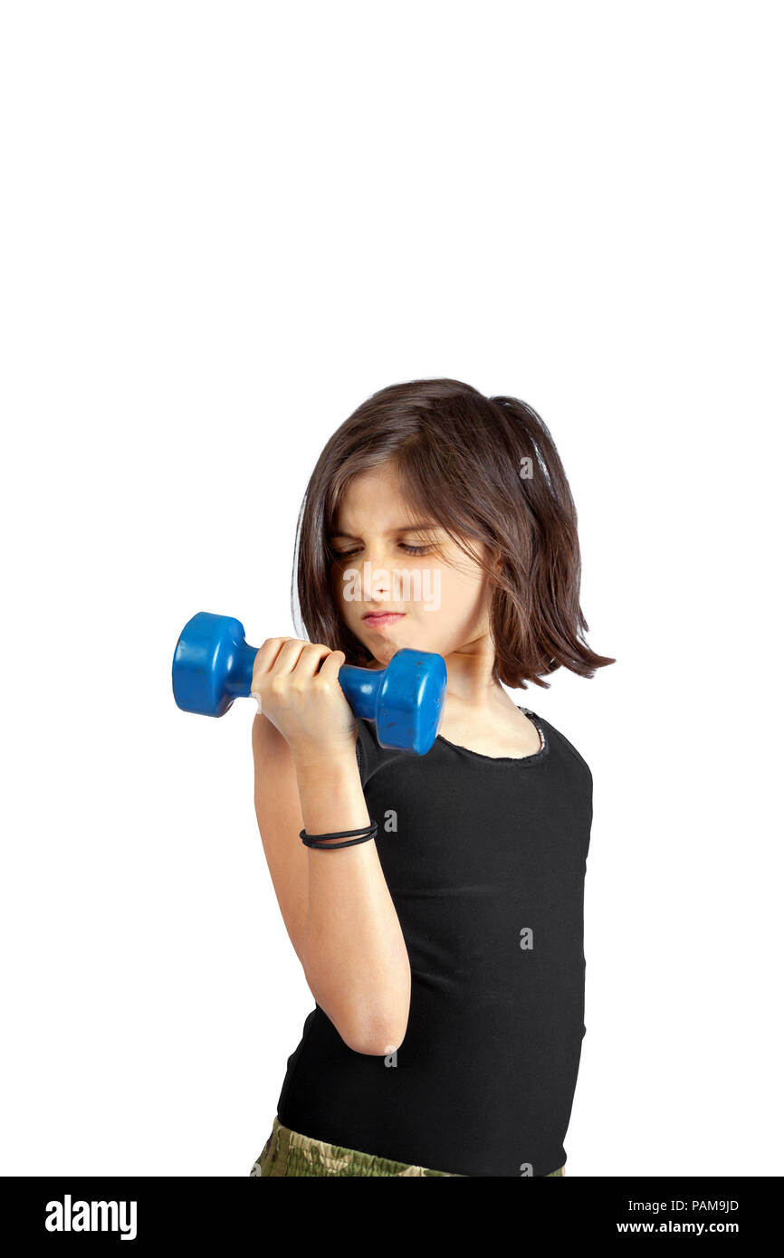 A young girl lifts a small, 5 lb dumbbell with a determined facial expression.   She is doing a bicep curl with improper form.  There are two ponytail Stock Photo
