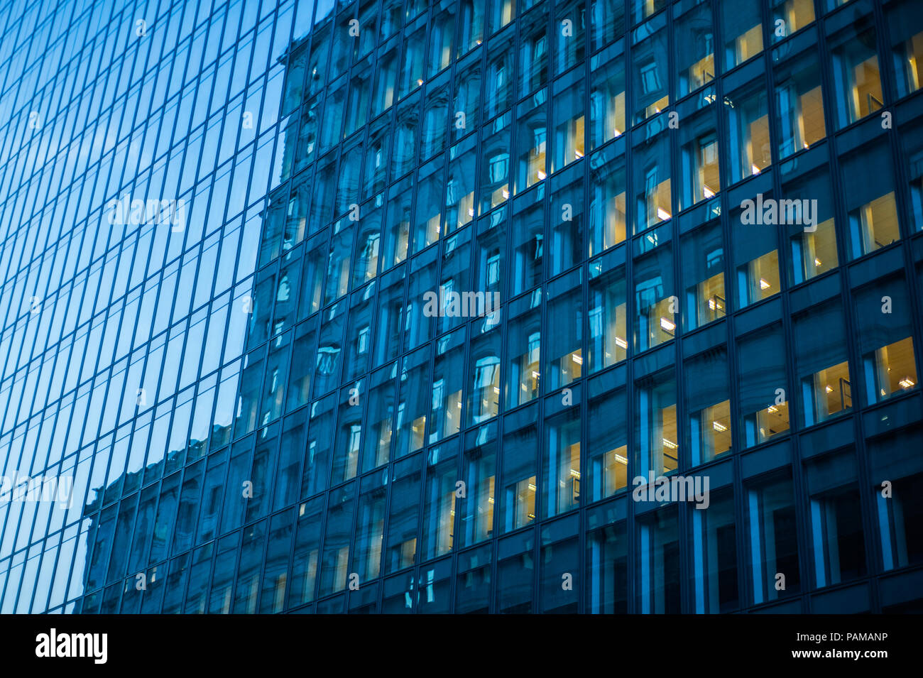 An office building is reflected on a skyscraper in downtown Montreal, Quebec. Stock Photo