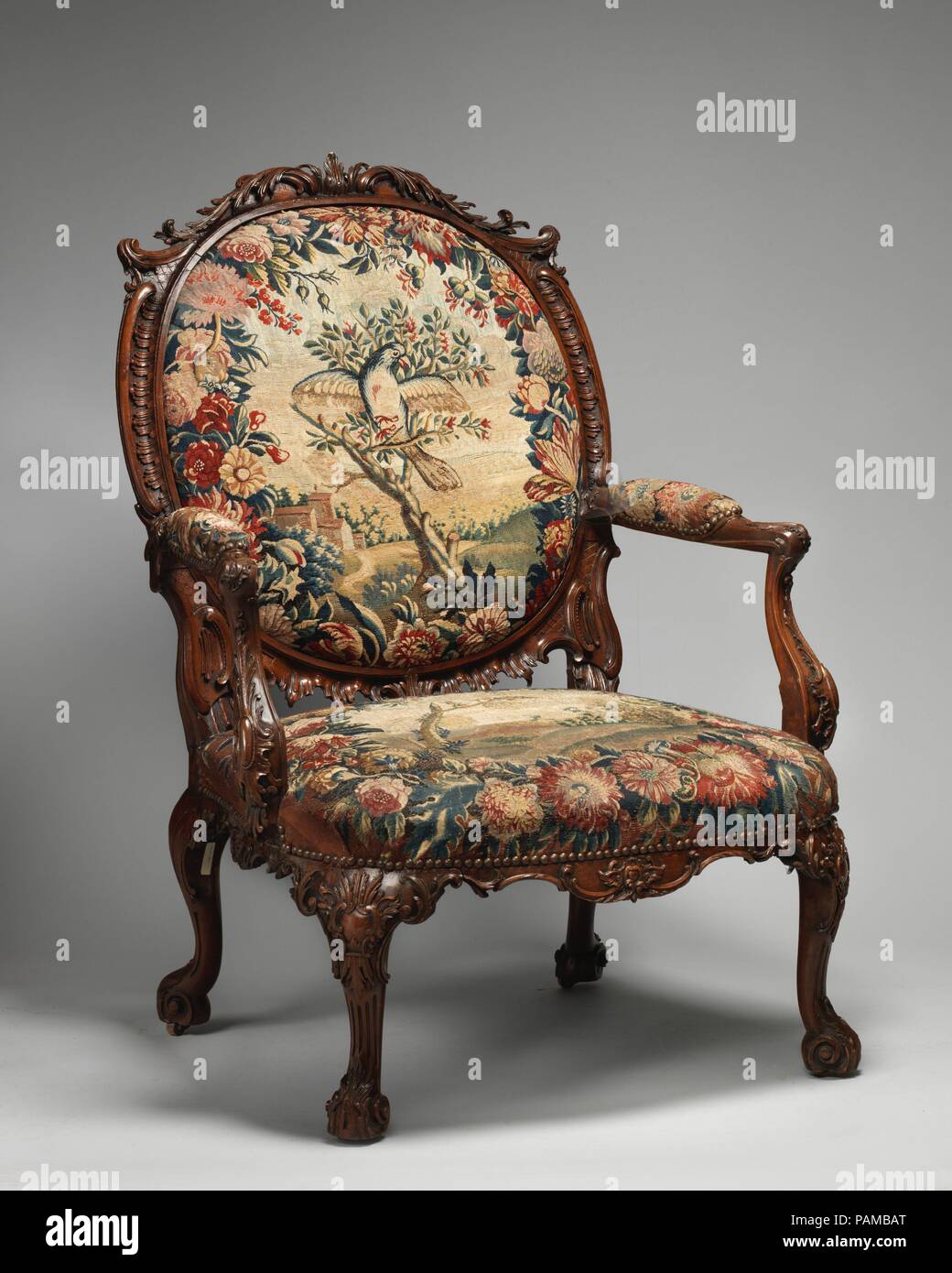 Armchair (one of four). Culture: British and French, probably Beauvais. Dimensions: Overall: 44 × 32 × 28 in. (111.8 × 81.3 × 71.1 cm). Factory: Tapestry probably woven at Royal Manufactory Beauvais 1664-1789. Date: 1755-65.  This rococo chair is part of a larger set of seat furniture supplied to the third Duke of Ancaster (1714-1778) for Grimsthorpe Castle, Lincolnshire. Executed in the French taste, fashionable in mid-eighteenth century England, the set was originally partly gilt and upholstered with Gobelins tapestry (now in the Rijksmuseum, Amsterdam) after designs by the painter François  Stock Photo