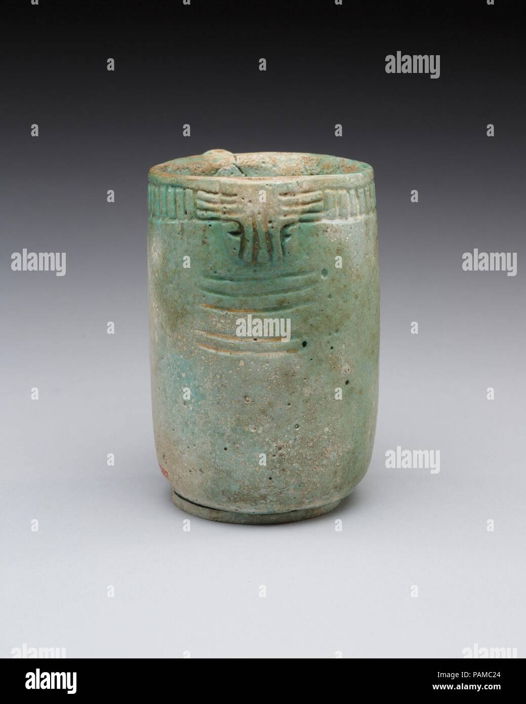 Jar with decorated rim, swivel, and knob. Dimensions: h. 7.5 cm (2 15/16 in.); diam. 5.5 cm (2 3/16 in.). Date: 664-30 B.C..  The color of this cylindrical vessel suggests a Late Period or Ptolemaic Period date. In a thickening on one side of the vessel's lip there is a hole for a swivel for the now missing lid. When meant to remain closed, string would have secured a knob on the lid to a knob protruding from the side of the vessel opposite the swivel. Museum: Metropolitan Museum of Art, New York, USA. Stock Photo
