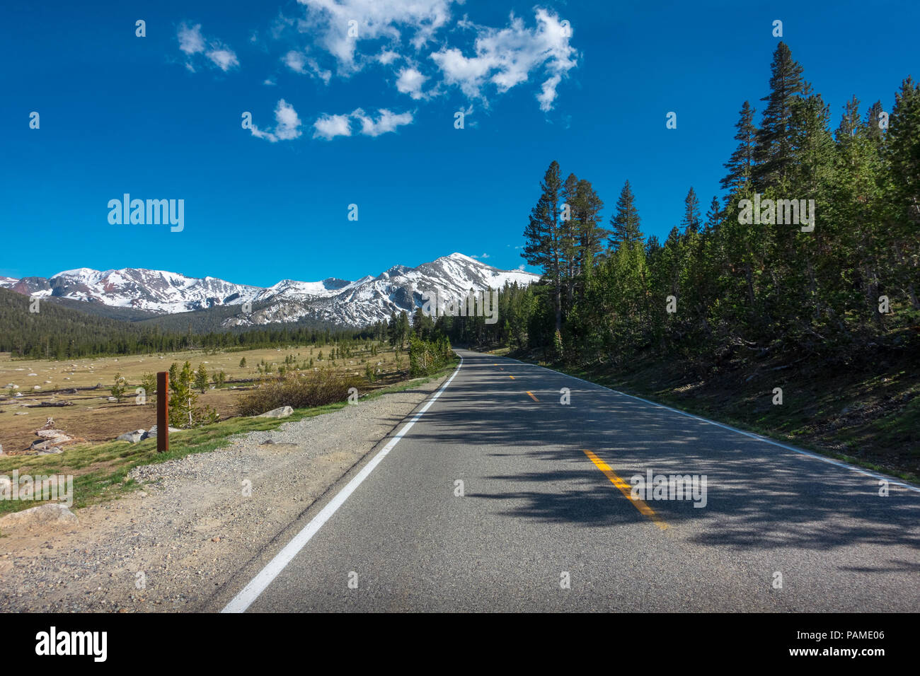 Open road stretching to snow covered Mammoth Peak, Mountains of Yosemite National Park Stock Photo