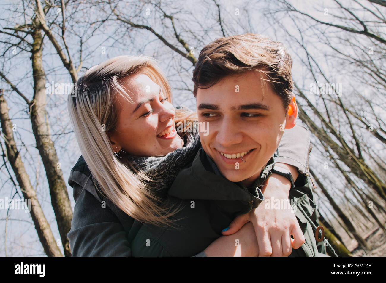 Cheerful loving each other couple kisses. Walk in the park and hug