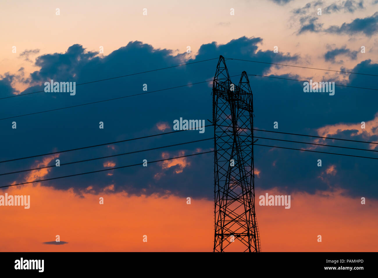 Silhouette of High voltage electric pylon, tower in sunset Stock Photo