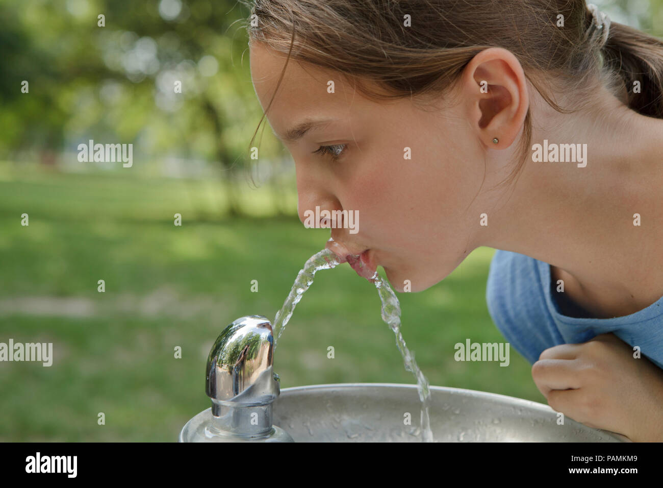 girl drinking water in Poland in hot summer day, high temperature in Central Europe Stock Photo