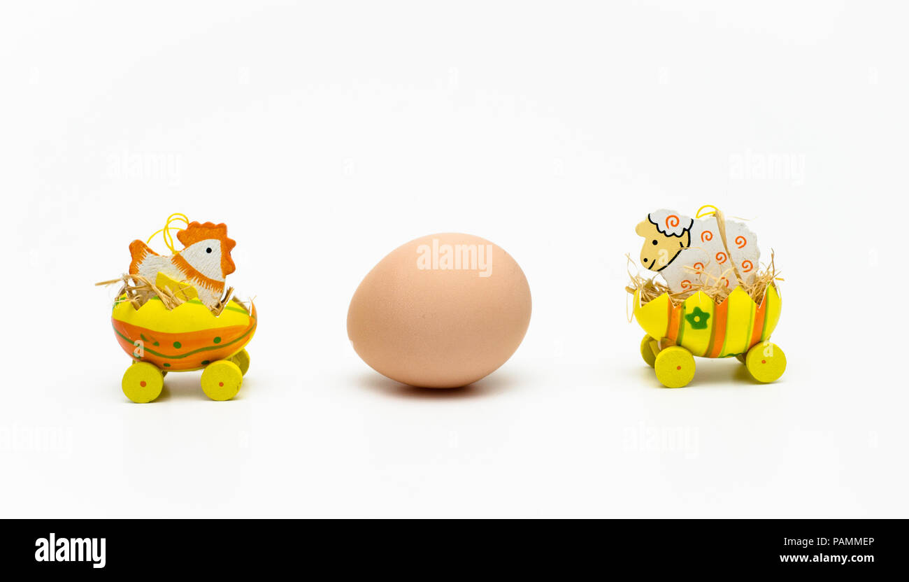 A chicken and a cow staring at an egg Stock Photo