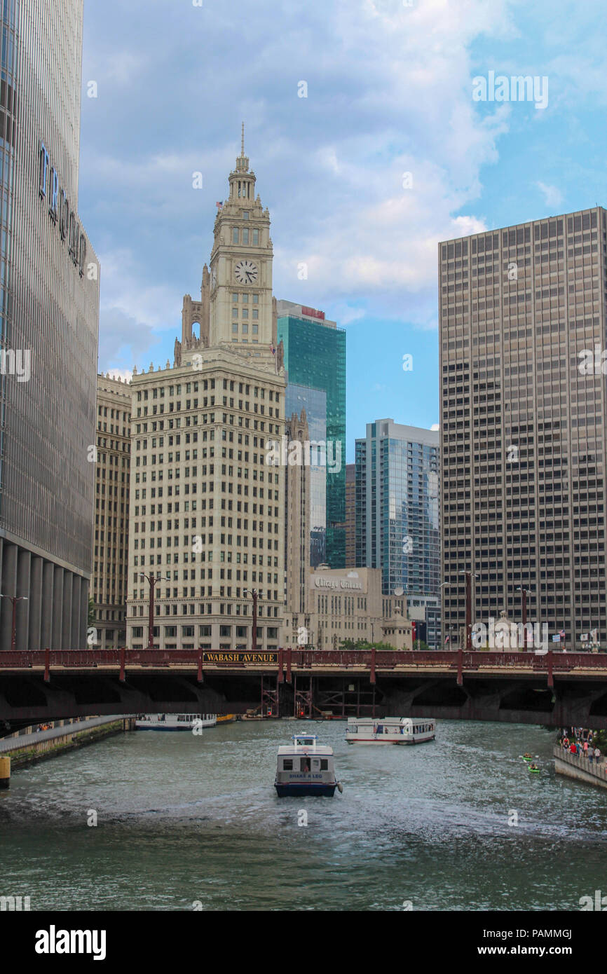 a boat passes under a bridge next to Trump Tower and Chicago Tribune in ...