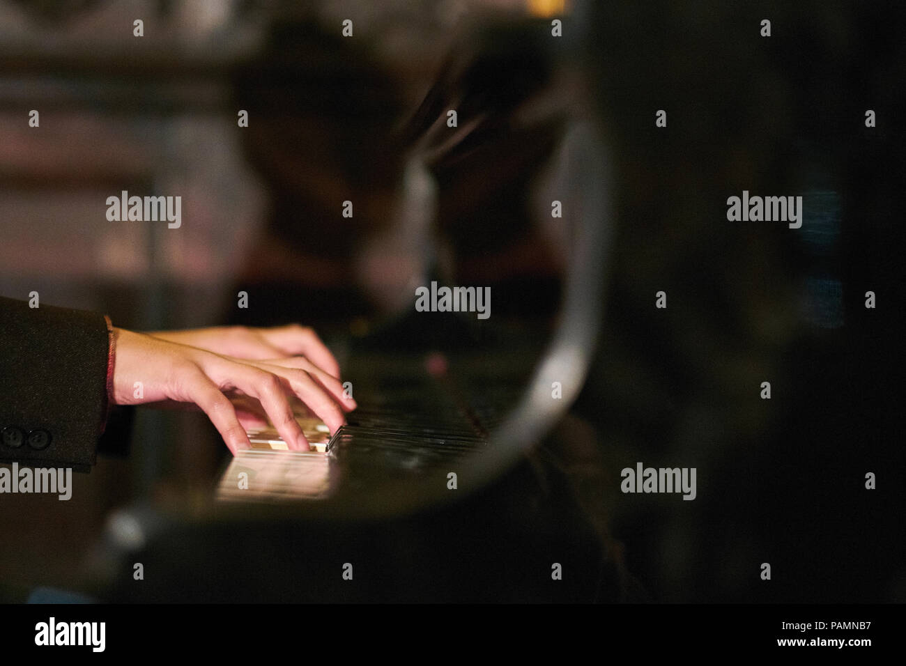 Pianist's hands playing a grand piano Stock Photo