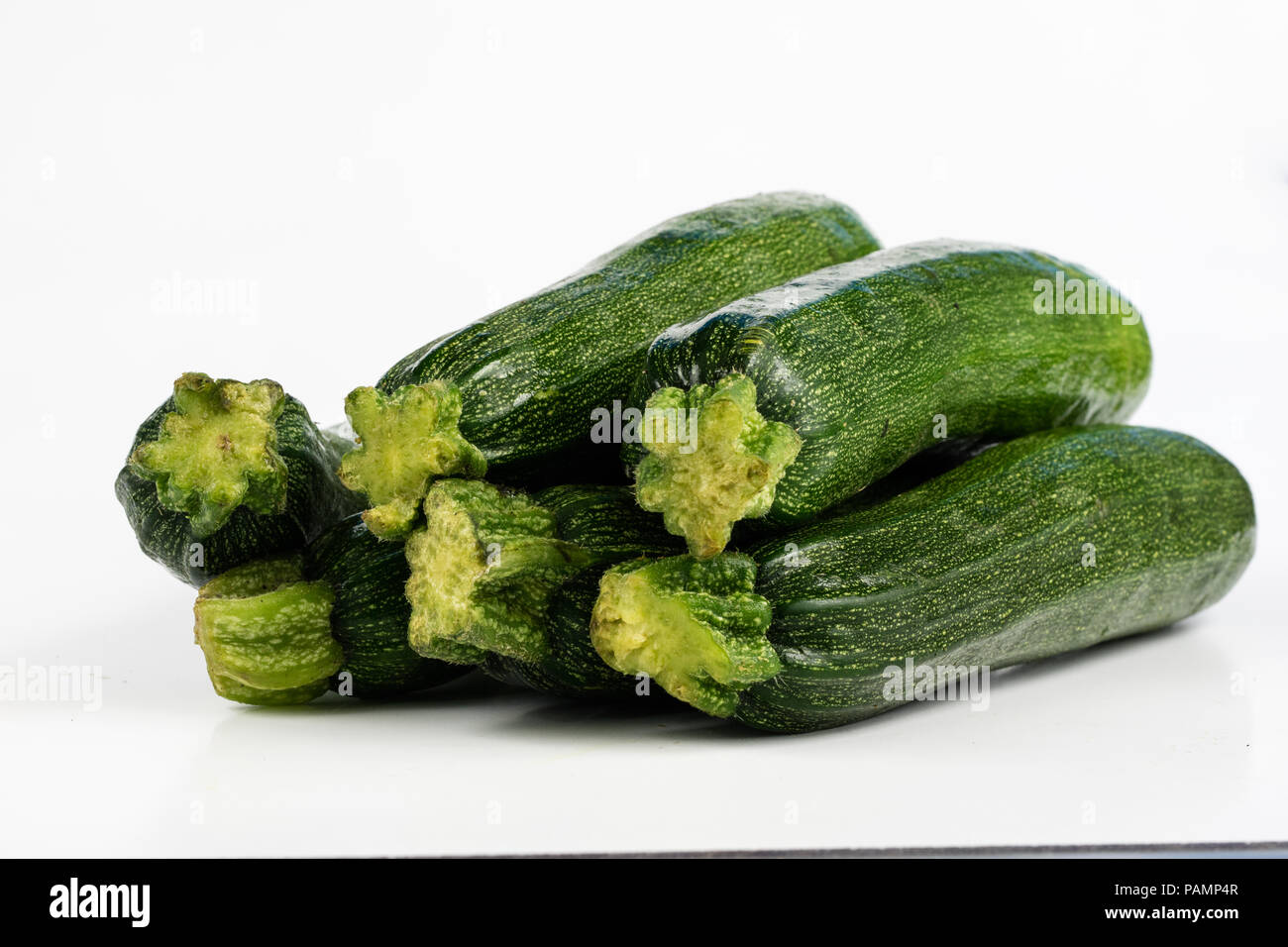 Zucchini on a white table. Tailor measure to measure the waist circumference during the diet