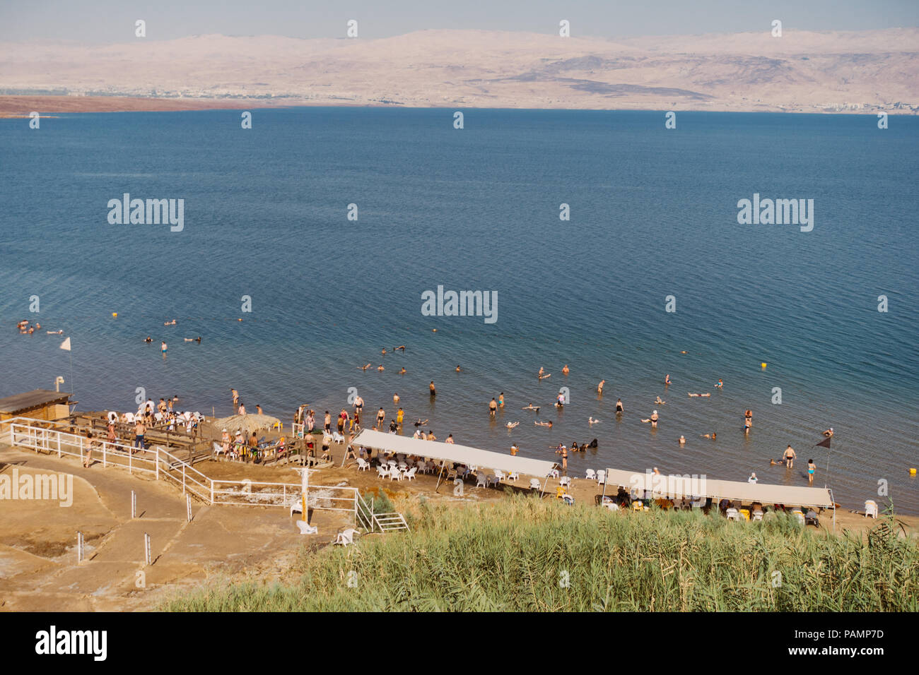 Tourists relax, swim and float in the Dead Sea, Israel, which is so salty it's impossible for a human body to sink Stock Photo