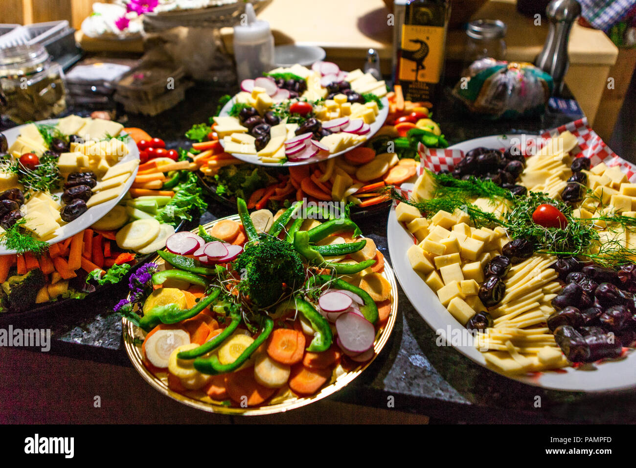 Food platters full of fresh vegetables, cheeses, sprouts and dates
