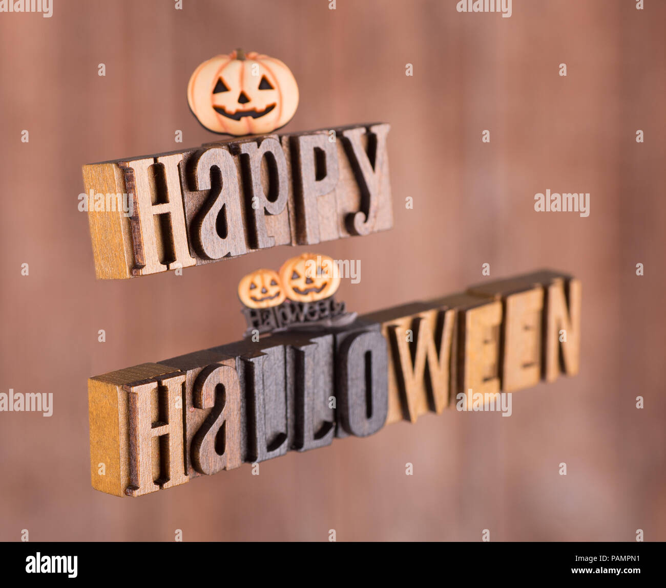 Wood letters spelling happy halloween floating on an orange background Stock Photo