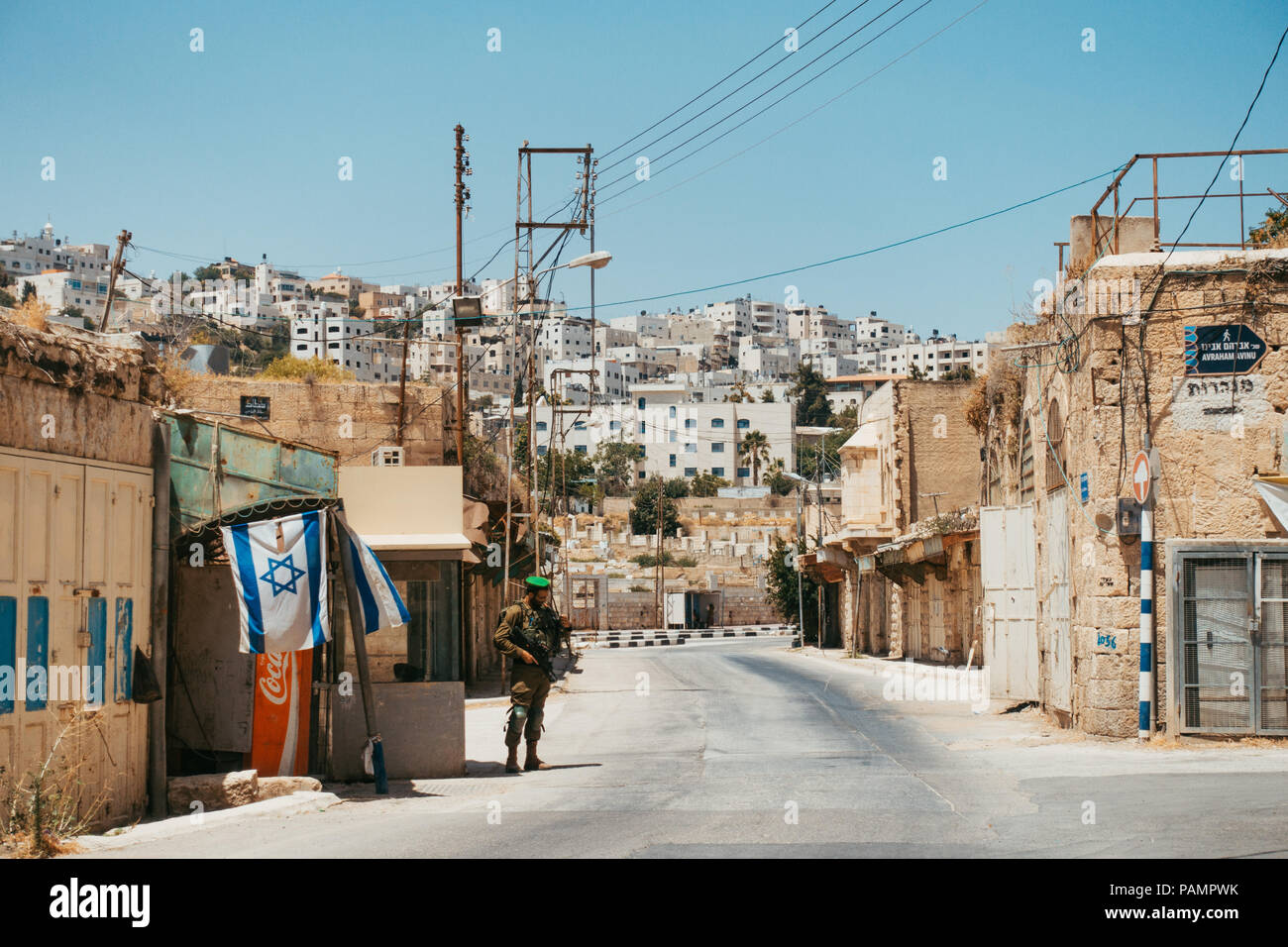 an Israel Defense Forces soldier stands guard prohibiting muslims from entering a Jews-only settlement in Hebron, Occupied West Bank Stock Photo