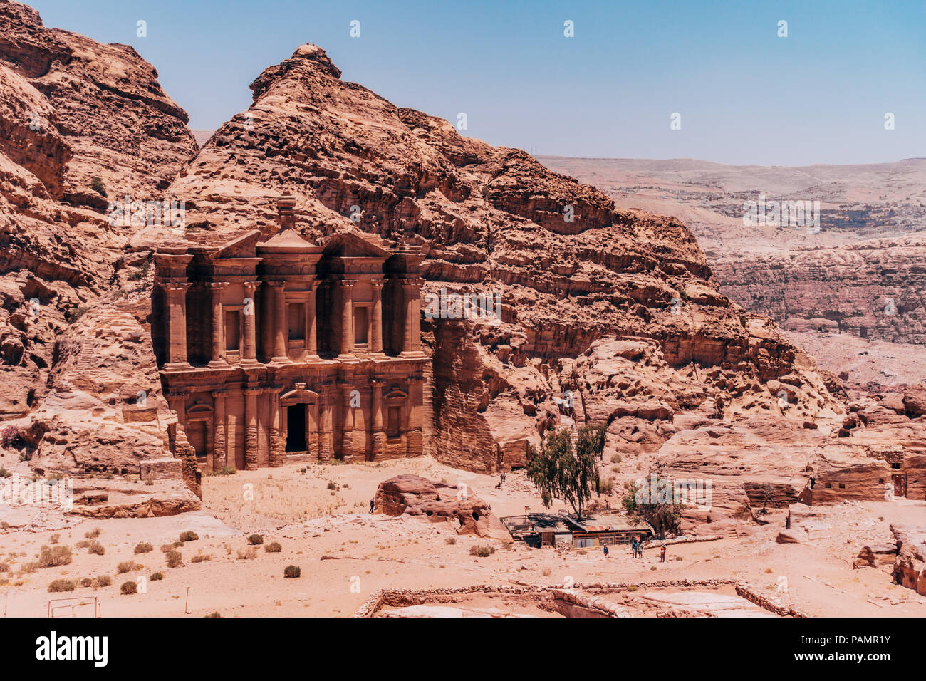 looking down at the Ad-Deir Monastery carved into the side of layers of rock in the Lost City of Petra, Jordan Stock Photo
