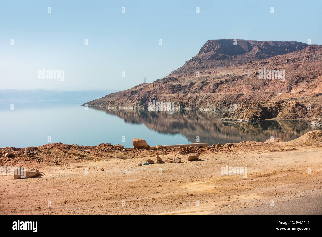 where sandy mountains meet the very reflective Dead Sea, on the Jordanian side Stock Photo