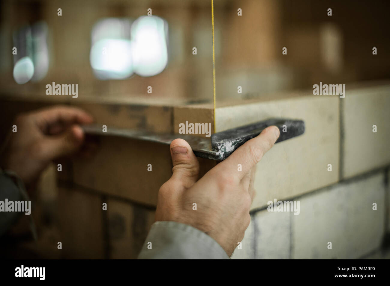 Brickmason using a square to build a brick wall Stock Photo