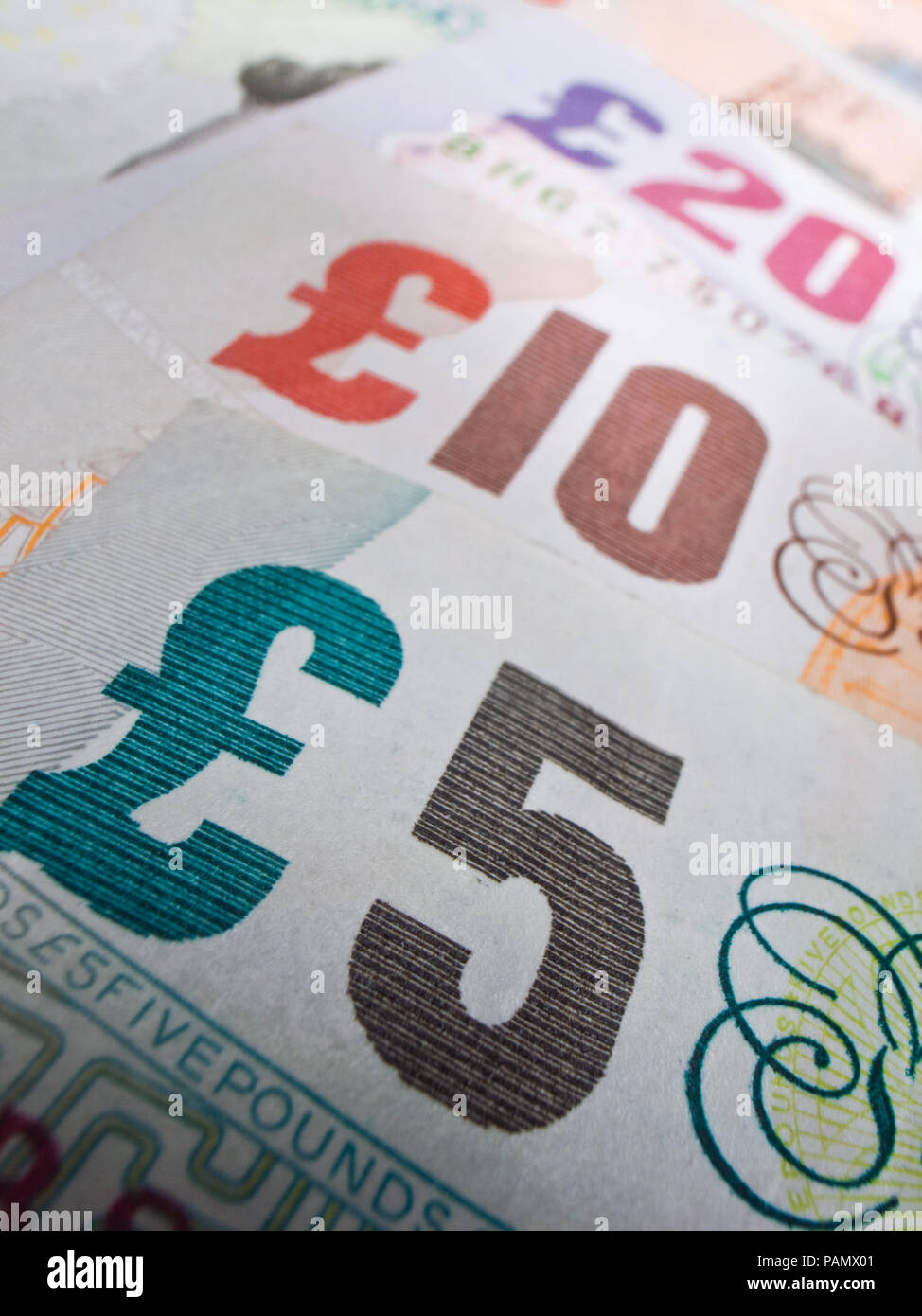 Close-up showing British bank notes in a line. Selective focus on the five pounds. Stock Photo