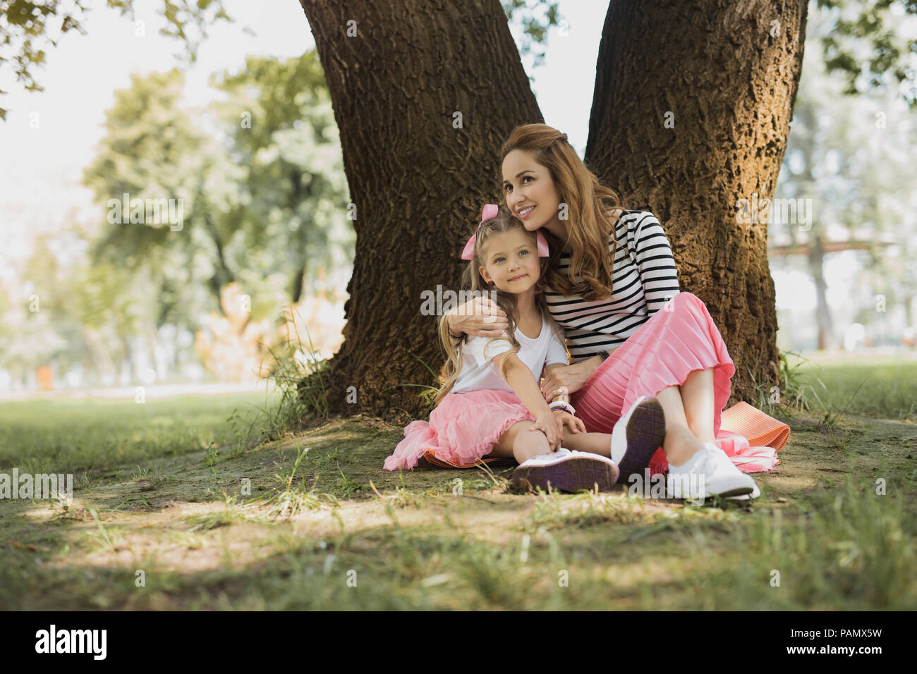 Stylish mother and daughter wearing pink skirts and white shirts Stock Photo