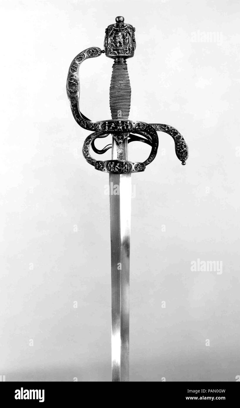 Rapier of Ambrogio Spinola (1569-1630) with Scabbard Chape. Culture: Northern European, possibly France. Dimensions: L. of sword 46 1/8 in. (117.1 cm); L. of blade 39 3/4 in. (101 cm); L. of chape 3 in. (7.6 cm). Hilt Maker: Hilt inscribed M. I. F. (northern European, active ca. 1600). Date: ca. 1600.  The hilt is finely decorated with small yet amazingly detailed scenes from the Old Testament, encircled by identifying inscriptions in Latin and French. The hilt is initialed M.I.F. three times by an unidentified medalist or sculptor. Inscribed on the back of the knuckle guard is the name of the Stock Photo