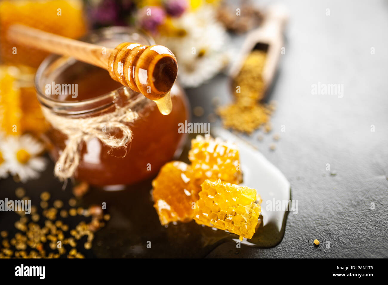 Honey jar and dipper with leaking honey Stock Photo Alamy