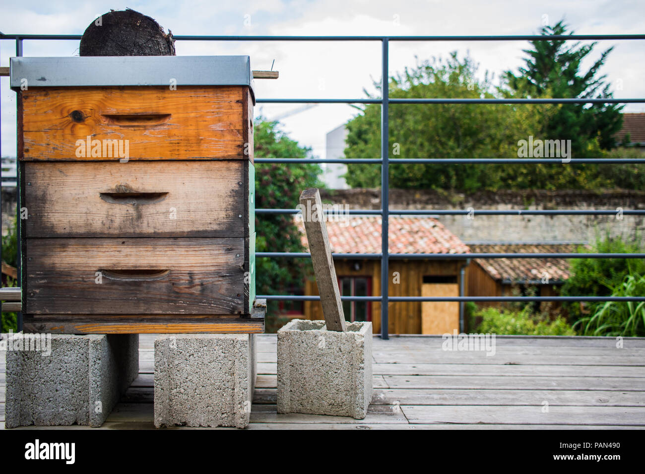 Urban agriculture with a yellow wooden bee hive on a balcony in