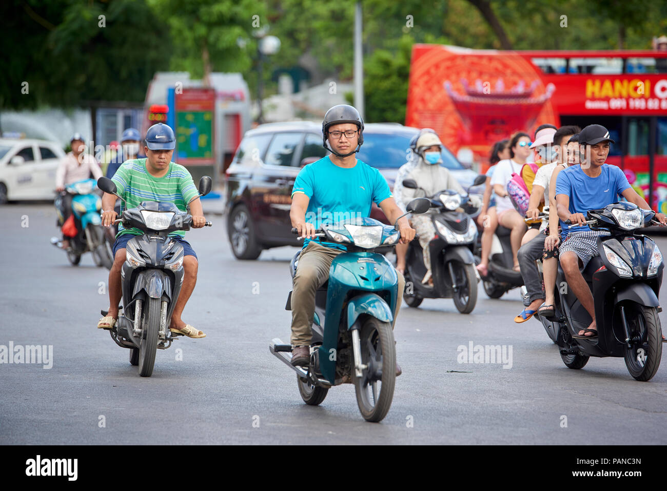 Moped riders in Hanoi, Vietnam. A ban on motorbikes and scooters has been set to 2030 by the city council and the department of transport. Stock Photo