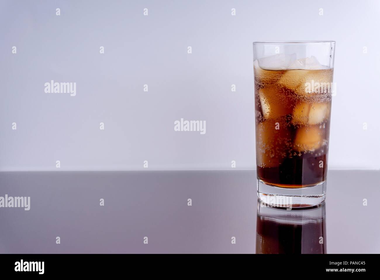 Cola in glass with ice cubes on white background Stock Photo - Alamy