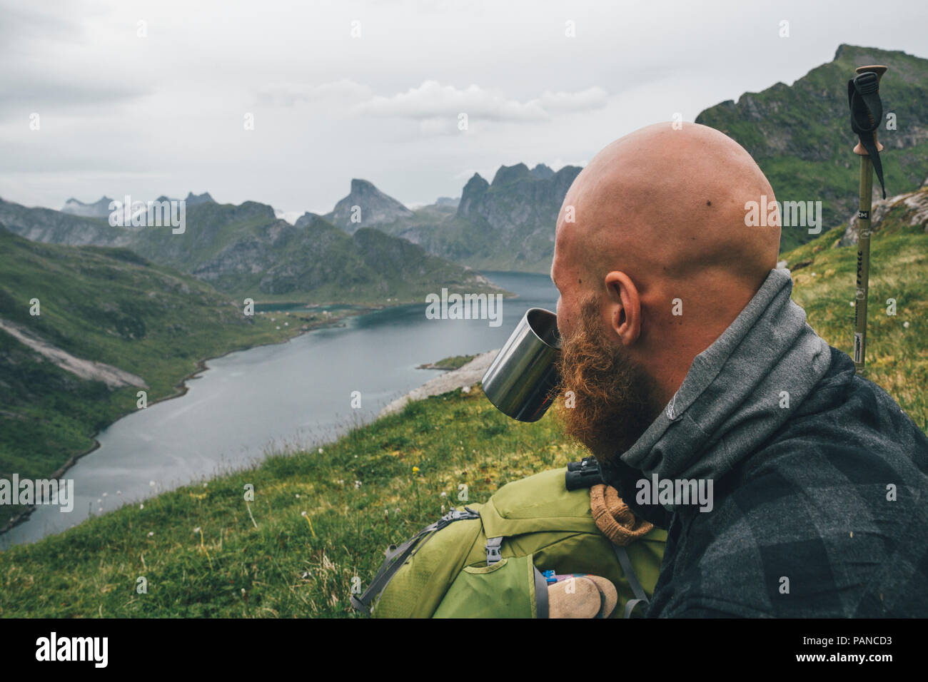 Norway, Lofoten, Moskenesoy, Man looking at view, drinking from tin cup Stock Photo