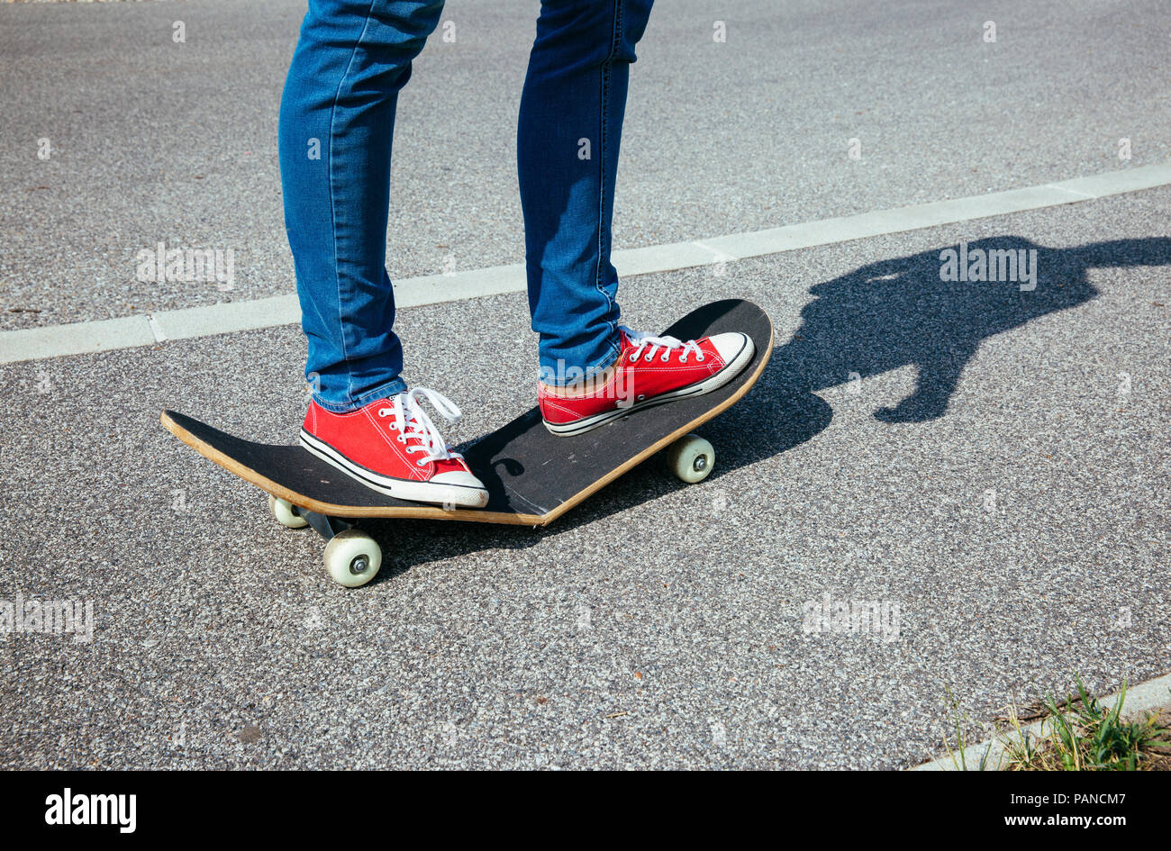 Woman standing on broken skateboard Stock Photo - Alamy