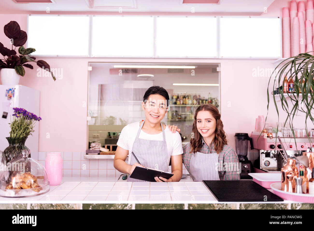 Two young smiling waiters preparing for workday Stock Photo
