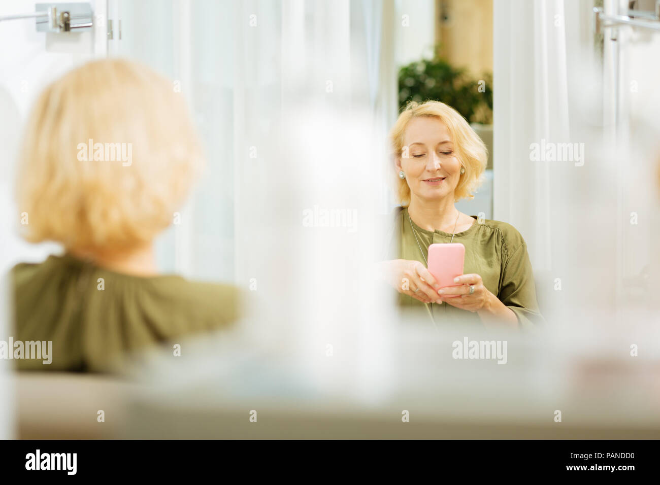Cheerful nice woman using her gadget Stock Photo