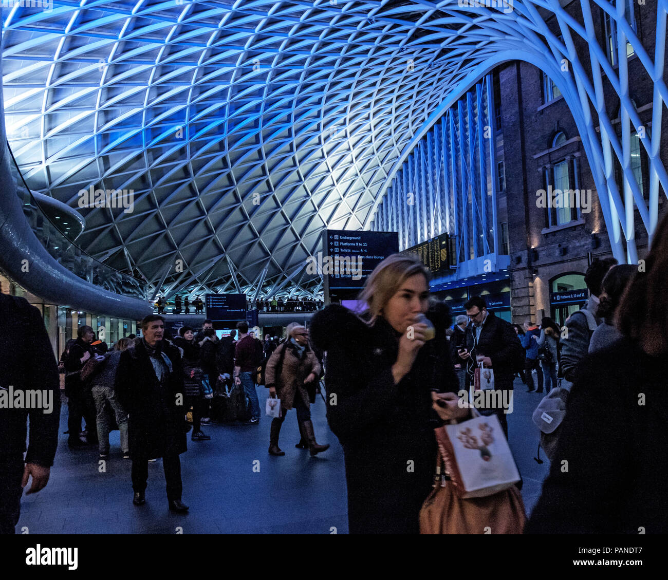 People wait for trains and walk in the Kings Cross Concourse, under the ...