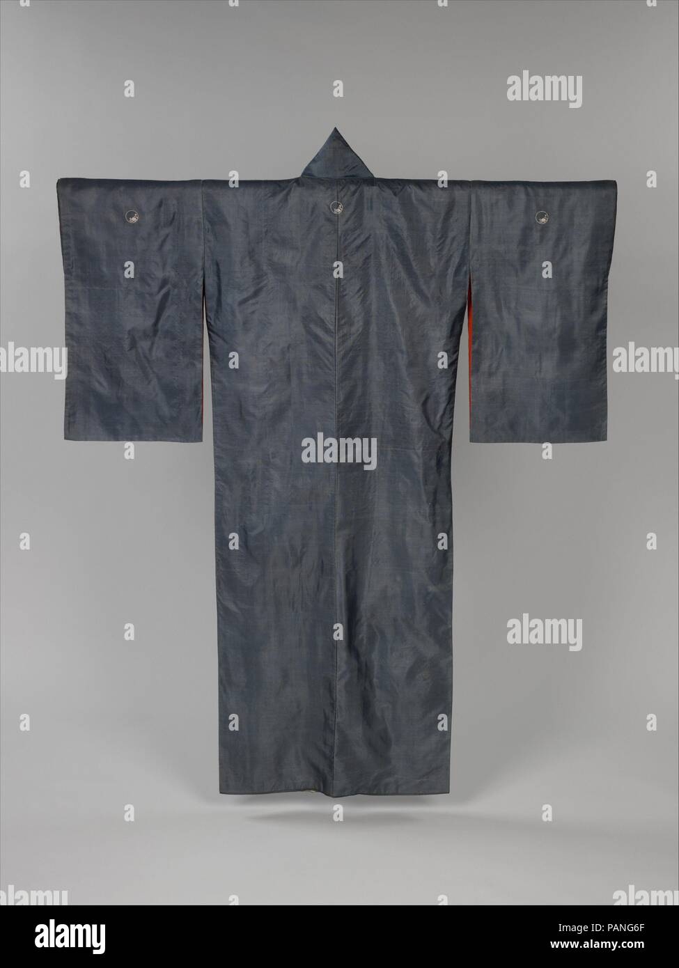 Kimono with Blossoming Plum Tree. Culture: Japan. Dimensions: Overall: 62 × 49 in. (157.5 × 124.5 cm). Date: second half of the 19th century.  Paste-resist dyeing, along with skillful use of a shading technique, finely renders the gradual progression from white to dark gray on this garment. Early Meiji period kimonos often have gray or black grounds and decoration concentrated along the hemline. Here, the plum tree, painted in ink and pigments and embroidered with silk and occasional glints of gold, seems to glow in soft moonlight, while the rest of the robe is in shadow. The design scheme is  Stock Photo