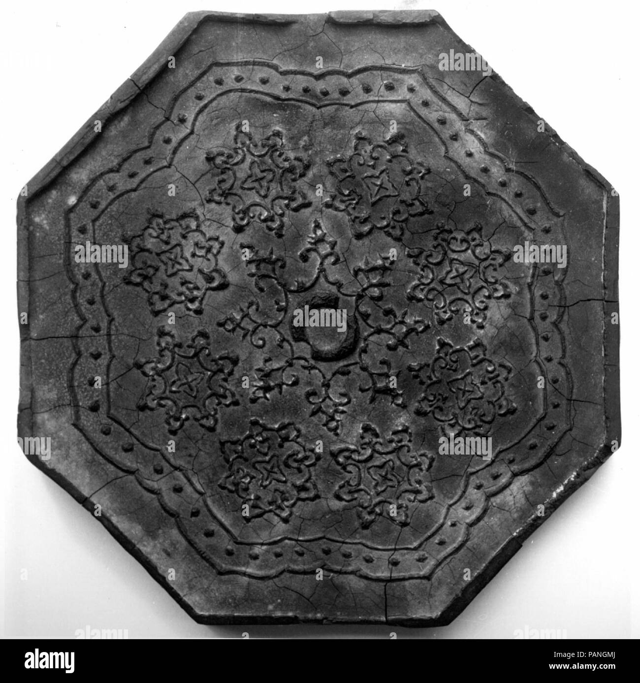 Ink Tablet with Tang Mirror Design. Culture: China. Dimensions: Diam. 4 3/8 in. (11.1 cm). Date: late 19th-early 20th century.  Woodblock illustrations were an important source of decorative designs during the late Ming and Qing dynasties. The eight-lobed, foliated Tang mirror decorating this octagonal ink cake was borrowed from an illustration in the Xinqing gujian (Catalogue of Xiqing Antiques), a compilation of the antiques collected in the Qing palace. A fictitious mark of Fang Yulu was added to this ink cake to increase its value. Museum: Metropolitan Museum of Art, New York, USA. Stock Photo