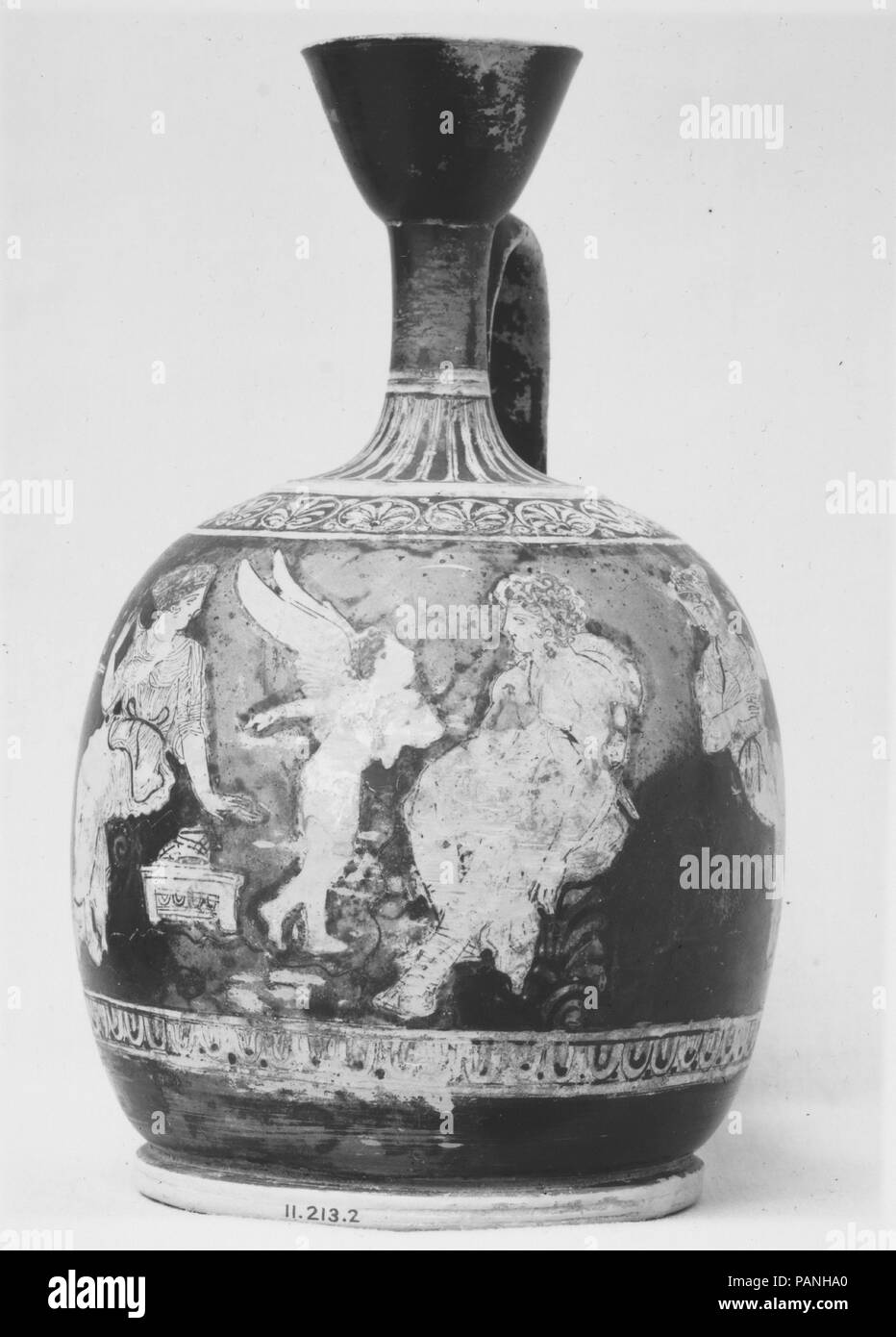 Terracotta squat lekythos (oil flask). Culture: Greek, Attic. Dimensions: H. 7 7/8 in. (20 cm)  diameter  4 3/4 in. (12.1 cm). Date: ca. 410 B.C..  The youth Chrysippos with Aphrodite, Eros, and Pompe  Chrysippos, wearing the boots, mantle, and broad-brimmed hat of a traveler, talks with Eros who points toward Aphrodite. Next to the goddess stands a casket, on it a pair of shoes. The woman to the left is unidentified, the other one is Pompe (the personification of procession). Beside her are traces of a ritual basket that would have been depicted in applied clay with gilding. The details of th Stock Photo