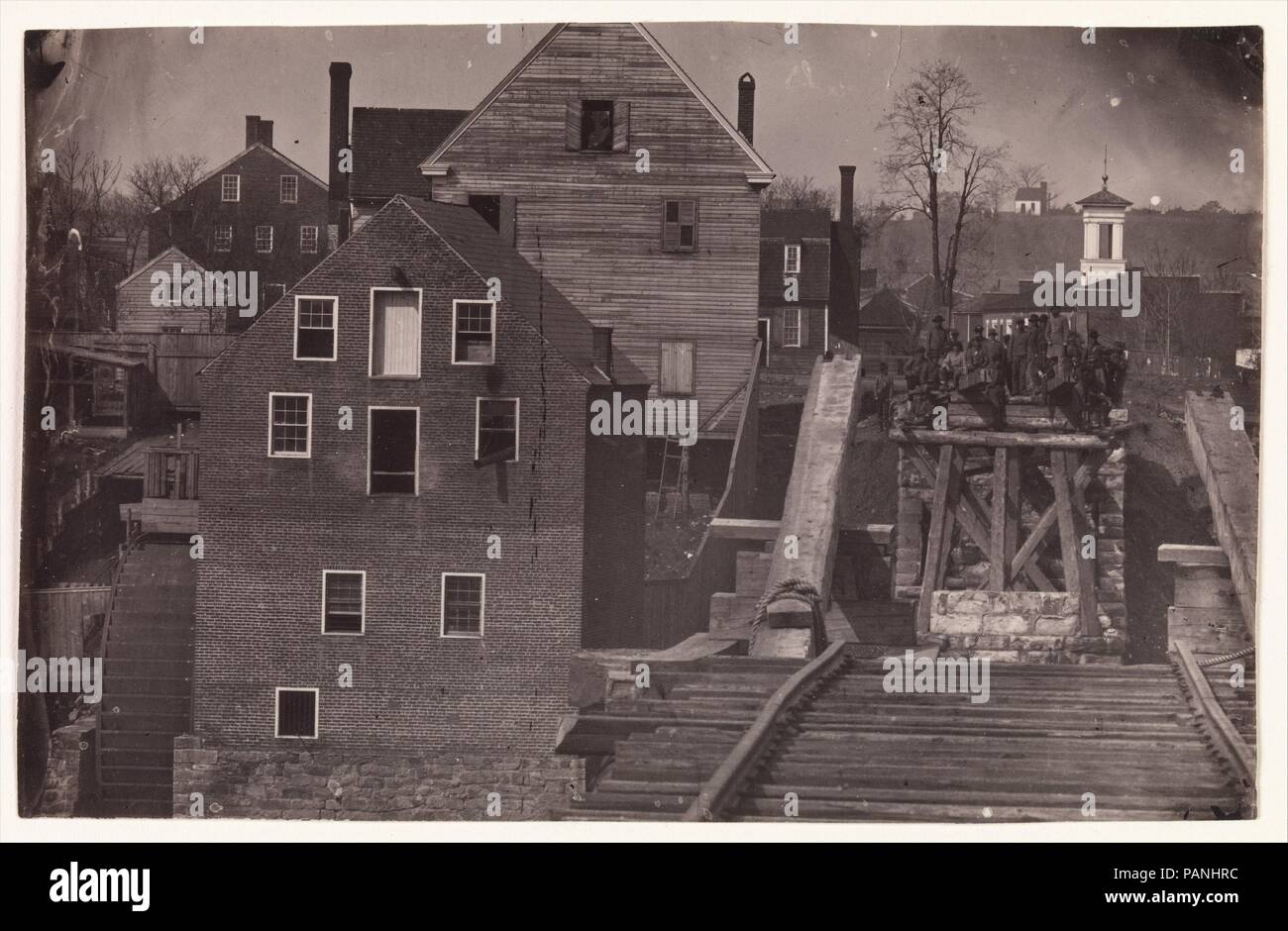 End of the Bridge after Burnside's Attack, Fredericksburg, Virginia. Artist: Andrew Joseph Russell (American, 1830-1902). Dimensions: Image: 13.1 × 20.6 cm (5 3/16 × 8 1/8 in.). Former Attribution: Formerly attributed to Mathew B. Brady (American, born Ireland, 1823?-1896 New York). Date: 1863.  Likely made in April 1863 during a truce just before the Battle of Chancellorsville, this view from the buttress of a ruined railroad bridge spanning the Rappahannock River at Fredericksburg documents a small group of Confederate soldiers and civilians. They stare across the divide at their fellow comb Stock Photo