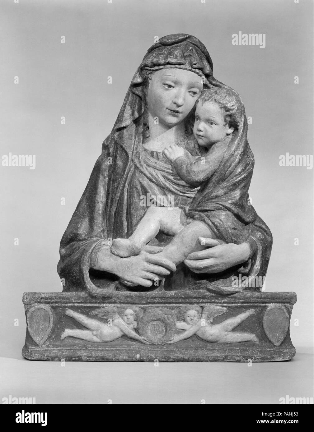 Madonna and Child. Artist: Probably after Lorenzo Ghiberti (Italian, Florence 1378-1455 Florence). Culture: Italian, Florence. Dimensions: Overall: 34 1/2 × 28 1/2 in. (87.6 × 72.4 cm). Date: ca. 1425-40.  This composition is apparently a variant of another Madonna relief which Ghiberti designed specifically to be molded and reproduced in painted stucco. See 08.22.3 for a painted stucco version of that composition. The type of base derives from the niche of the Parte Guelfa on Or San Michele by Donatello, finished in 1423. See 07.120.3 for a terracotta version of this composition. Museum: Metr Stock Photo