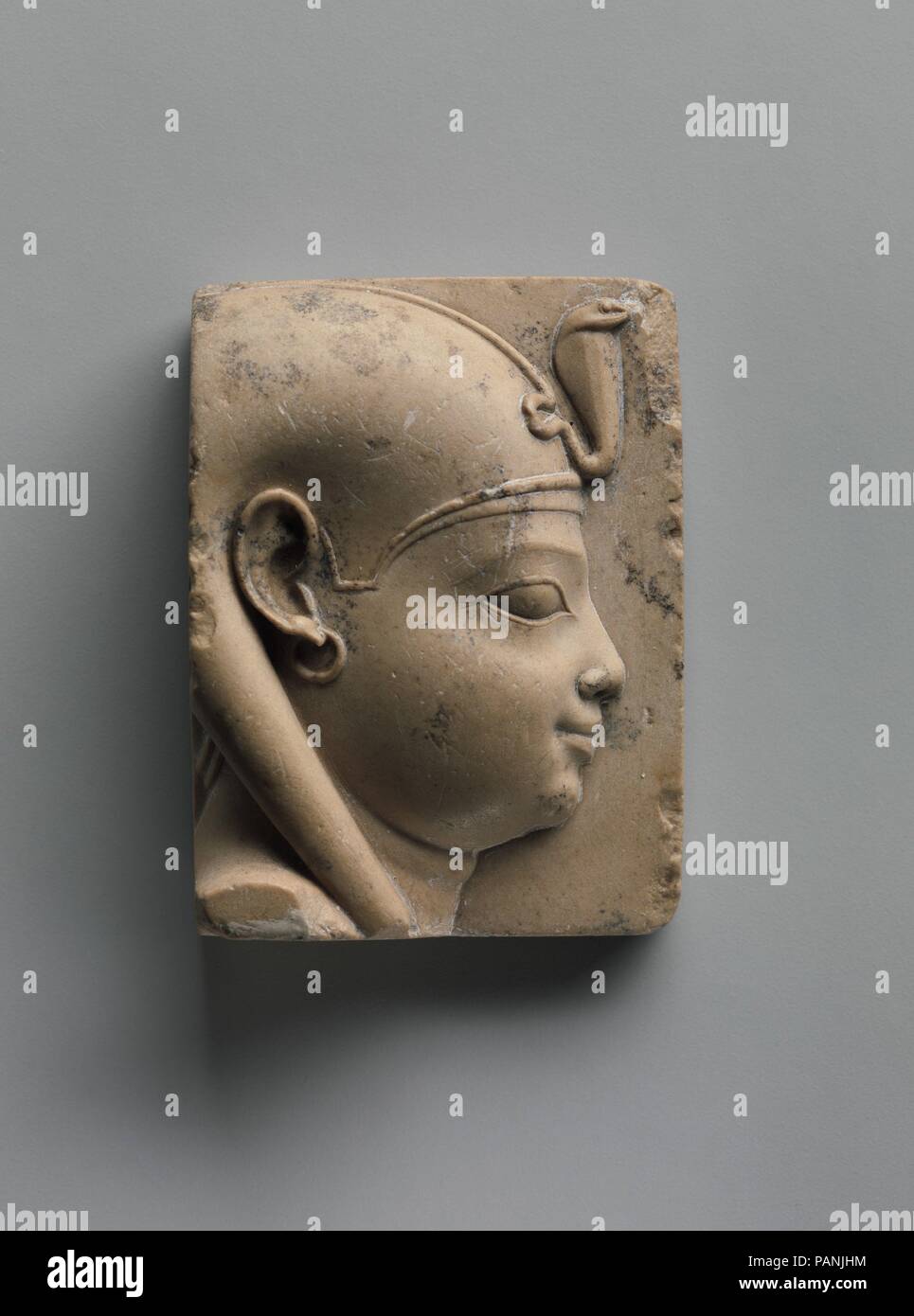 Plaque with bust of a divine child with earring (Ihy?). Dimensions: H 5.7 x W 4.2 cm (2 1/4 x 1 5/8 in). Date: 400-30 B.C..  Small Late Period and Ptolemaic reliefs or sculptures that depict a subject in a partial or unfinished way but are themselves finished  constitute a special class of object. Guidelines like those for artists are often prominently exhibited as part of the object, although, in fact, many instances can be noted where the object simply could not serve as a suitable model for a traditional formal Egyptian representation. Personifications of kingship, figures that may represen Stock Photo