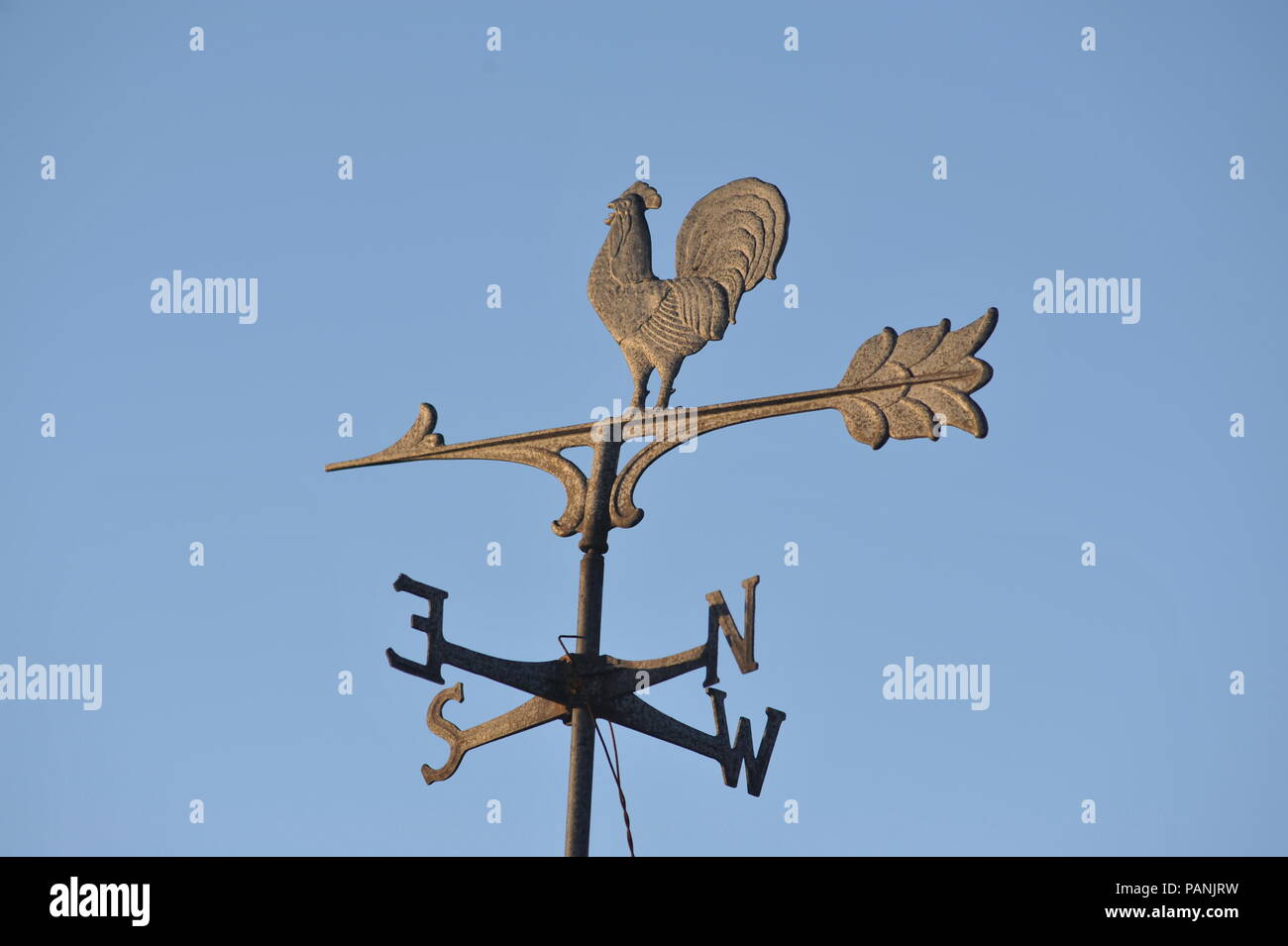 Directional weather vane in the form of a rooster marking north, south, east and west, with arrow with feathers, atop which the rooster stands, USA. Stock Photo
