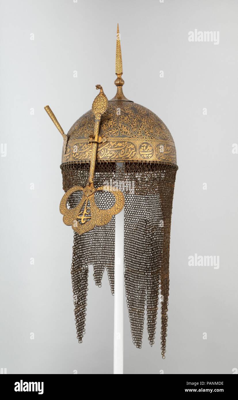 Helmet, Shield, and Arm Guard. Culture: Deccan, Indian. Dimensions: Helmet (a); H. including mail 24 in. (61 cm); H. including nasal 17 in. (43.2 cm); H. excluding mail and nasal 10 in. (25.4 cm); W. 9 1/4 in. (23.5 cm); D. 10 5/8 in. (27 cm); Wt. 3 lb. 1.2 oz. (1394.8 g). Date: 17th-19th century.  The pierced faceguard, topped with the popular Indian motif of the cobra, offered protection without impairing the wearer's vision. The phrase 'O 'Ali' in the center is bordered by the following inscription: 'There is no hero or man like 'Ali; there is no sword like <i>Dhu'l Fiqar</i>. Help from All Stock Photo