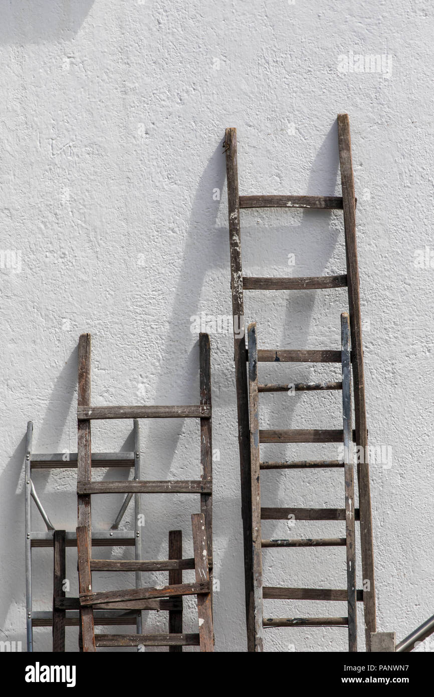 Wooden ladders leaning against a white wall Stock Photo Alamy