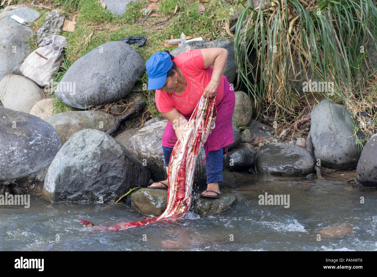 Latin American woman doing her laundry in a city stream Stock