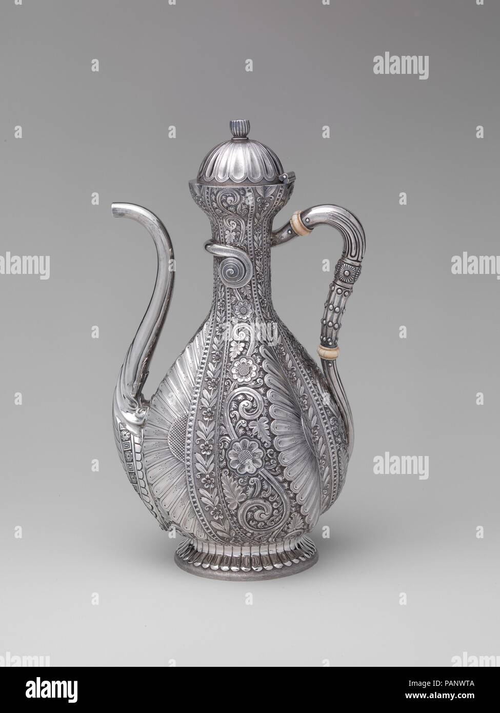 Coffeepot. Culture: American. Dimensions: 10 5/8 × 6 × 4 7/8 in., 30oz. 9dwt. (27 × 15.2 × 12.4 cm, 947.2g). Manufacturer: Gorham Manufacturing Company (American, 1831-present). Date: 1881.  Made as singular or limited production 'specials,' this sinuous coffee pot and tray epitomize the eclectic tastes and sensibilities that characterize the Aesthetic movement.  Here exotic near-eastern forms and decoration are combined with conventionalized plant motifs inspired by the British design reform movement.  The exquisitely crafted result is an inventive amalgam that is at once complex and coherent Stock Photo