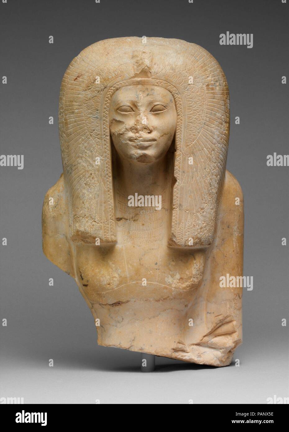 Upper Part of the Seated Statue of a Queen. Dimensions: H. 28 cm (11 in.); W. 17.8 cm (7 in.); D. 10 cm (3 15/16 in.). Dynasty: Late Dynasty 17-Early Dynasty 18. Date: ca. 1580-1550 B.C..  This image of a queen wearing the vulture headdress over a voluminous tripartite wig was split off its backslab in antiquity, most probably by somebody who wanted to make use of this conveniently shaped piece of stone for other purposes. It is conceivable that a king (her father, son, or husband) was originally represented seated beside her. The sculpture has been identified tentatively as Queen Ahmes Nefert Stock Photo